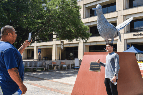 Father and son taking photo at Rowdy statue